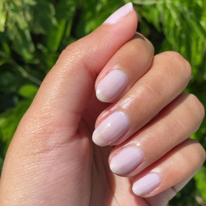 Hand with softly shimmery lavender nails in natural light showcasing the Violet Bliss mani and manicure polish set