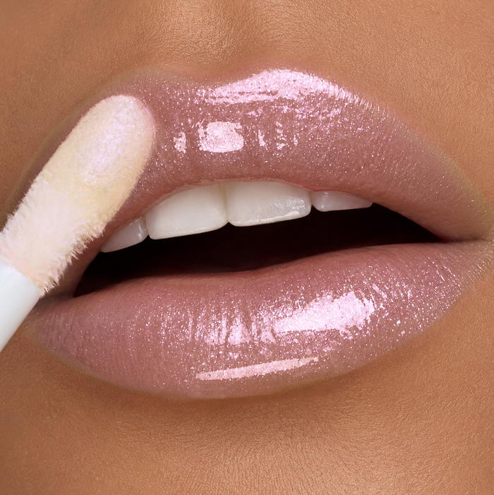 lip close-up of a woman applying Runway Rogue Loaded Lip Oil in the shade 'Angel Lights'