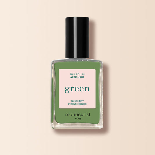 A bottle of Manucurist Artichoke nail polish from the Green™ range, featuring a black cap and a square label with the product name and description on a light beige background.