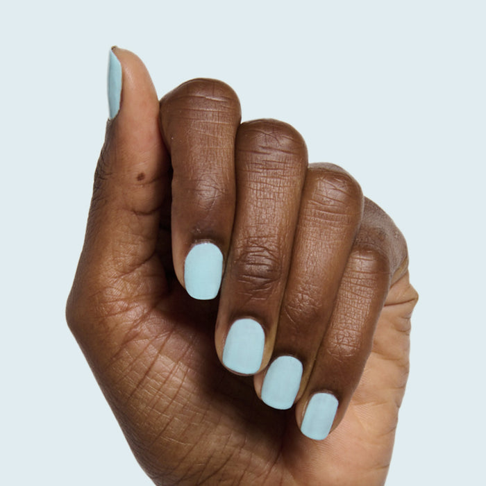 Hand with short rounded nails painted pastel soft turquoise in Berry Basket polish by Olive and June