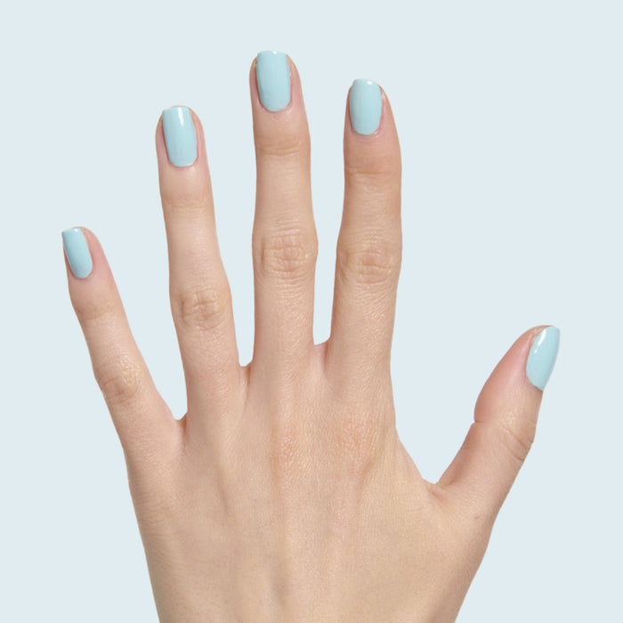 Hand with medium-length nails painted pastel soft turquoise in Berry Basket gel polish by Olive and June