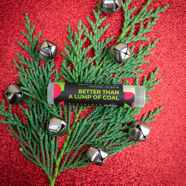Better Than a Lump of Coal lip balm on festive holiday greenery