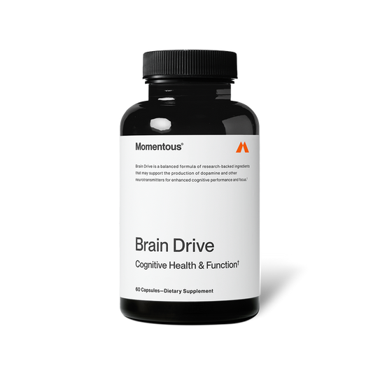 A black bottle of Momentous Brain Drive dietary supplement is shown centered on a black background with a white label. Text on the label reads: “Momentous®” “Brain Drive is a balanced formula of research-backed ingredients that may support the production of dopamine and other neurotransmitters for enhanced cognitive performance and focus.†” “Brain Drive” “Cognitive Health & Function†” “60 Capsules—Dietary Supplement”