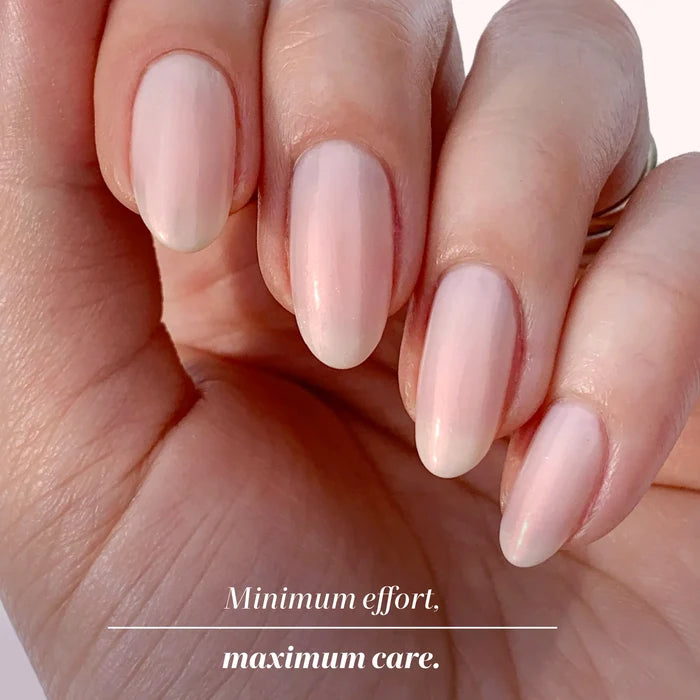 A hand with neatly manicured, oval-shaped nails painted in Bubble Illuminating Nail Concealer by LONDONTOWN. Text below reads: "Minimum effort. Maximum care.