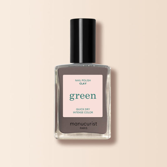 A bottle of Manucurist Clay nail polish in taupe gray, featuring a black cap and a beige label with "Nail Polish Clay, green, Quick Dry Intense Color, manucurist Paris.
