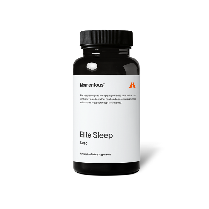 Black bottle of Momentous Elite Sleep dietary supplement on a black background. Label reads: “Momentous,” “Elite Sleep is designed to help get your sleep cycle back on track with five key ingredients that can help balance neurotransmitters and hormones to support deep, lasting sleep†.” Product name reads: “Elite Sleep,” “Sleep,” and “60 Capsules—Dietary Supplement.”