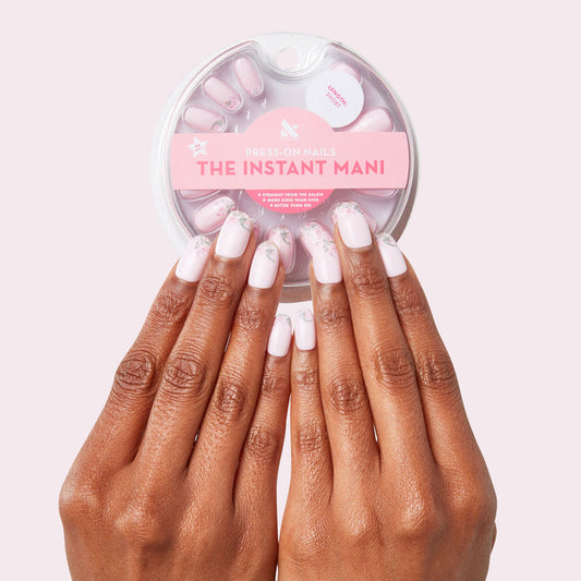 Hands wearing Faded Florals - Press-On | Short | Round with faded pink floral tips and round shape press-on nails