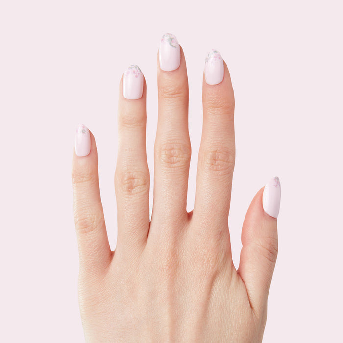 Hand with Faded Florals - Press-On | Short | Round featuring soft pink nails and subtle floral designs at the tips