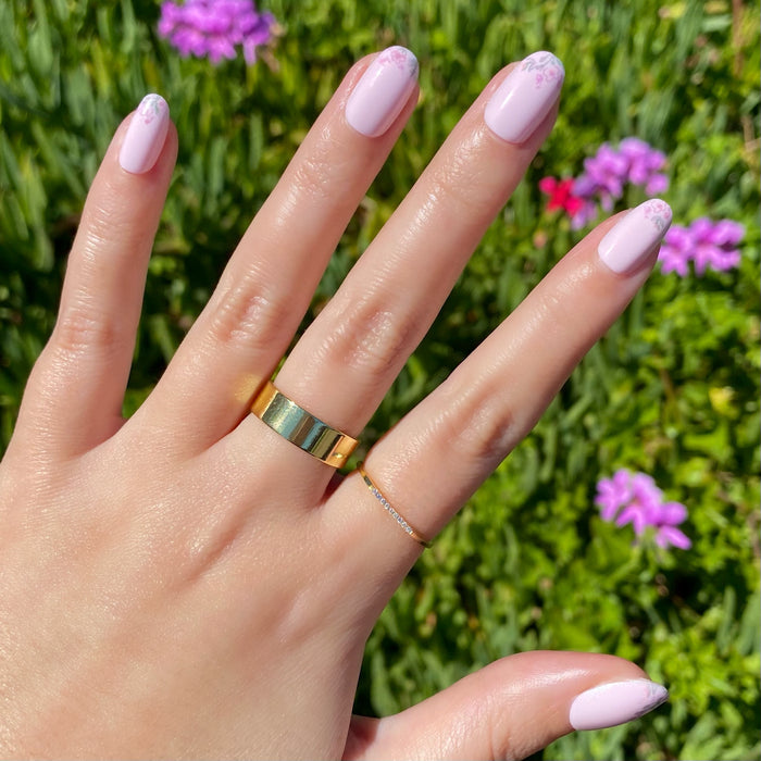 Hand with Faded Florals - Press-On | Short | Round featuring soft pink nails and delicate faded floral tips in natural light