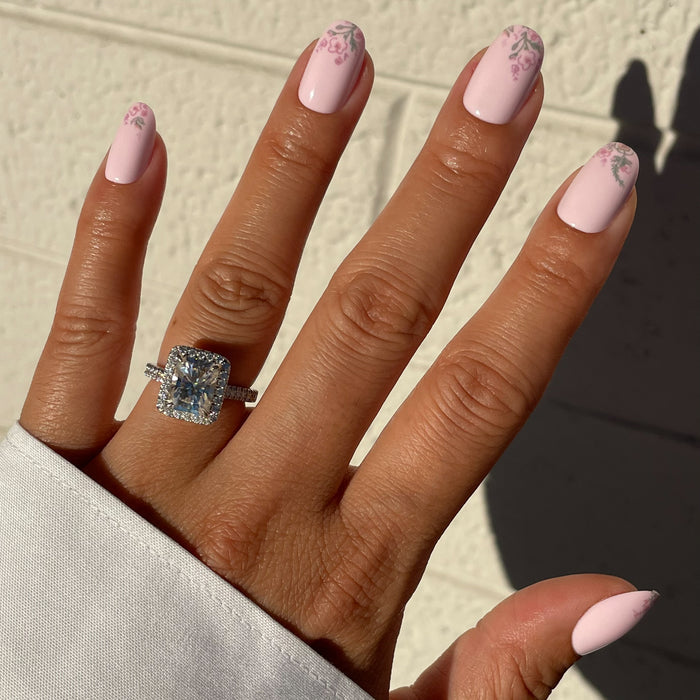 Hand with Faded Florals - Press-On | Short | Round featuring soft pink nails and delicate faded floral designs near tips in natural light