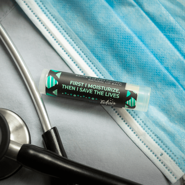 Lip balm, stethoscope, and mask on medical scrubs.