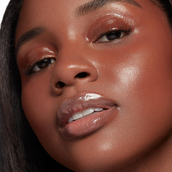 Glossy, plumped lips wearing It’s a Date, ColourPop So Juicy Plumping Glossy Lip Oil, catching light with a glass-like shine, shown in a close-up beauty shot with dewy skin and warm copper eyeshadow for a fresh, full-lip look.