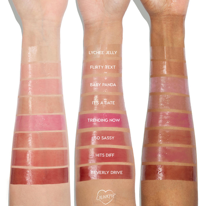 It’s a Date So Juicy Plumping Glossy Lip Oil by ColourPop swatched on three arms (light, medium, deep); the It’s a Date shade is fourth from top on the center arm, a sheer rosy pink with high shine, shown beside labeled shades for comparison.
