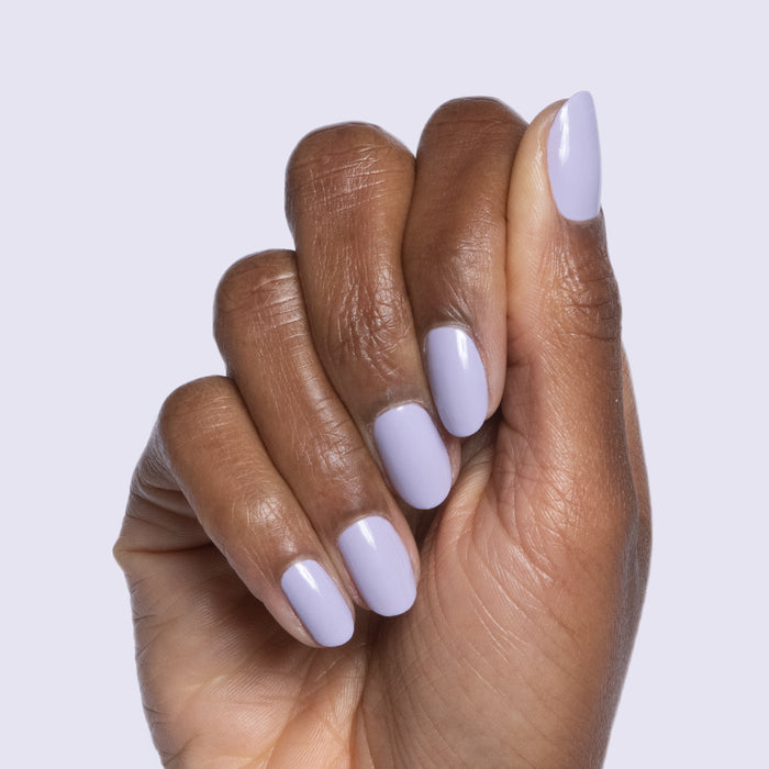 Hand with nails painted in pastel lavender Jacaranda gel polish against a soft neutral background for quick dry mani