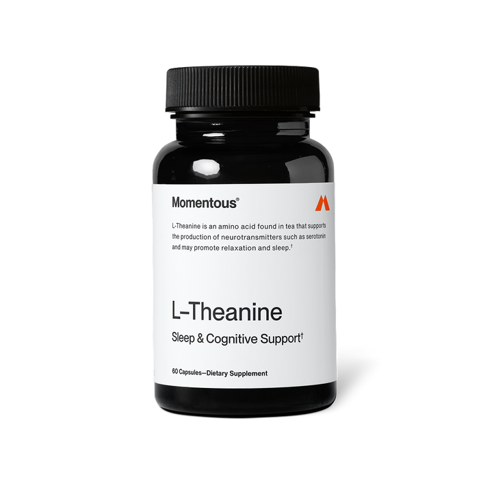 Black bottle of Momentous L-Theanine capsules with a white label on a black background. Text on the label reads: “Momentous®” “L-Theanine is an amino acid found in tea that supports the production of neurotransmitters such as serotonin and may promote relaxation and sleep.†” “L-Theanine” “Sleep & Cognitive Support†” “60 Capsules—Dietary Supplement”
