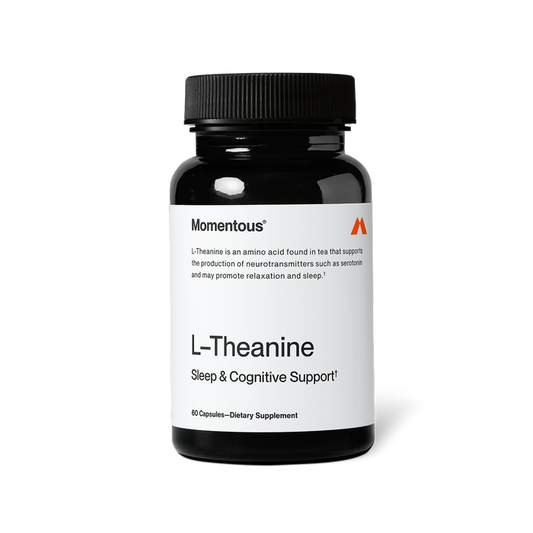 Black bottle of Momentous L-Theanine capsules with a white label on a black background. Text on the label reads: “Momentous®” “L-Theanine is an amino acid found in tea that supports the production of neurotransmitters such as serotonin and may promote relaxation and sleep.†” “L-Theanine” “Sleep & Cognitive Support†” “60 Capsules—Dietary Supplement”