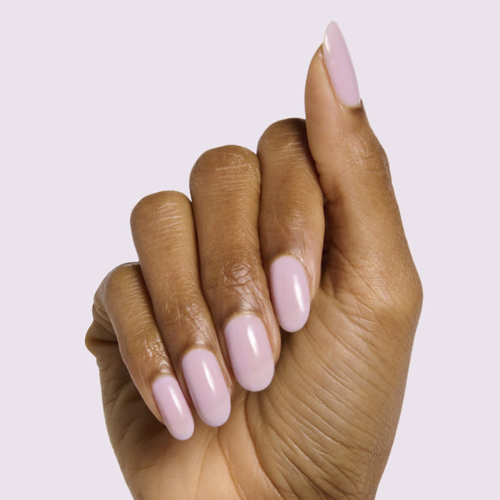 Hand with medium-length nails painted soft milky lavender in Lavender Stems gel polish by Olive and June