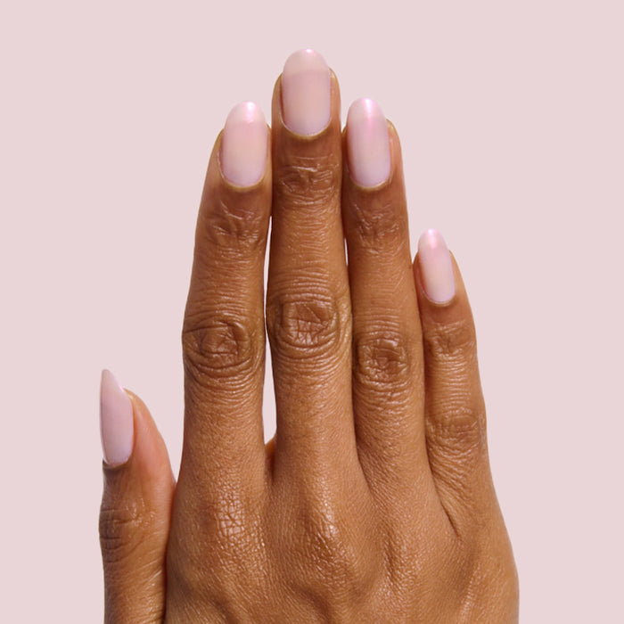 Hand with nails painted in soft milky pink gel polish Lucky Oyster for a delicate long-lasting manicure
