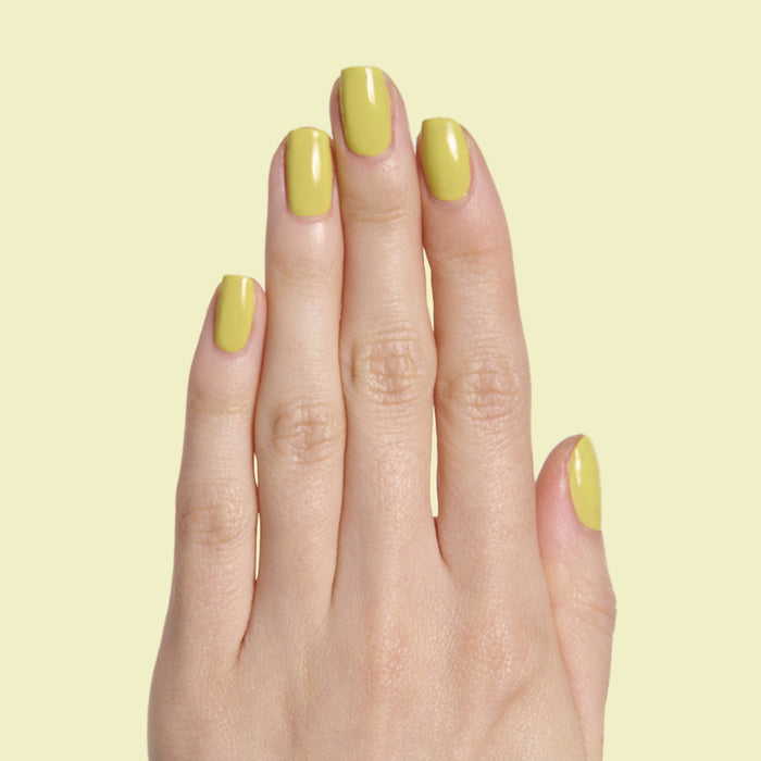 Hand with medium-length nails painted shiny chartreuse green in Not Kale gel polish by Olive and June