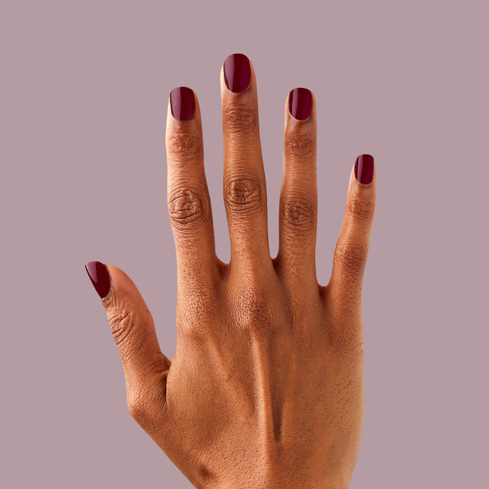 Obsessed - Press-On | Extra Short | Round on hand showing rich dark ruby red false nails for an elegant mani look