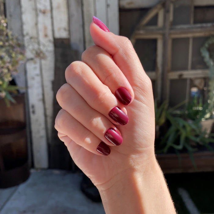 Obsessed - Press-On | Extra Short | Round hand showing glossy deep ruby red false nails for a polished manicure look