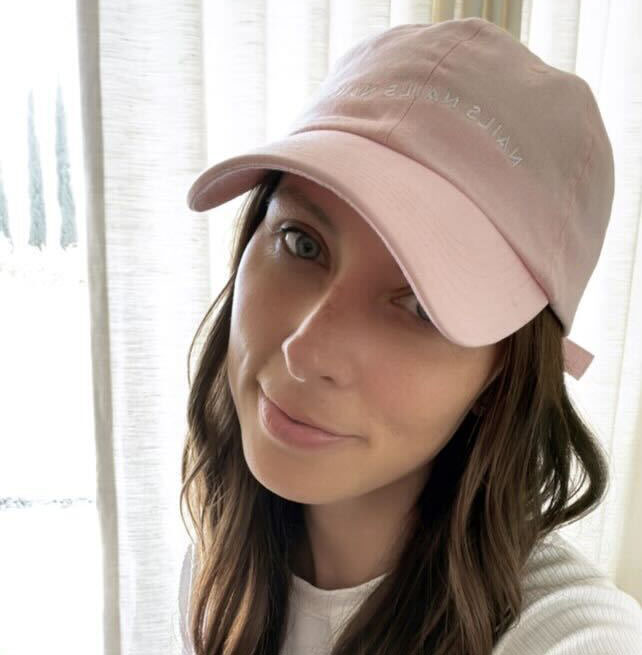 O&J Nails Hat in soft pink cotton twill featuring subtle Nails Nails Nails embroidery and adjustable strap worn by woman
