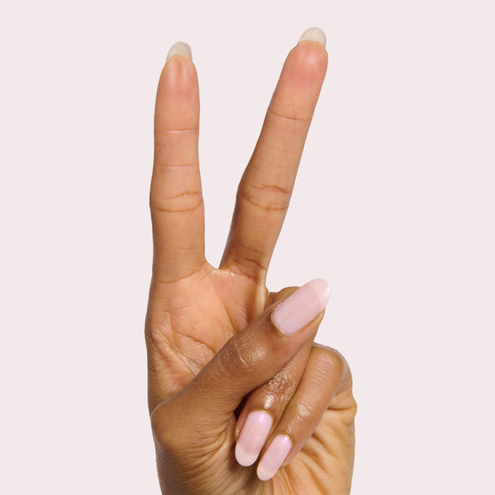 Hand showing two fingers with milky pink iridescent Pink Capiz nail polish for a delicate manicure look