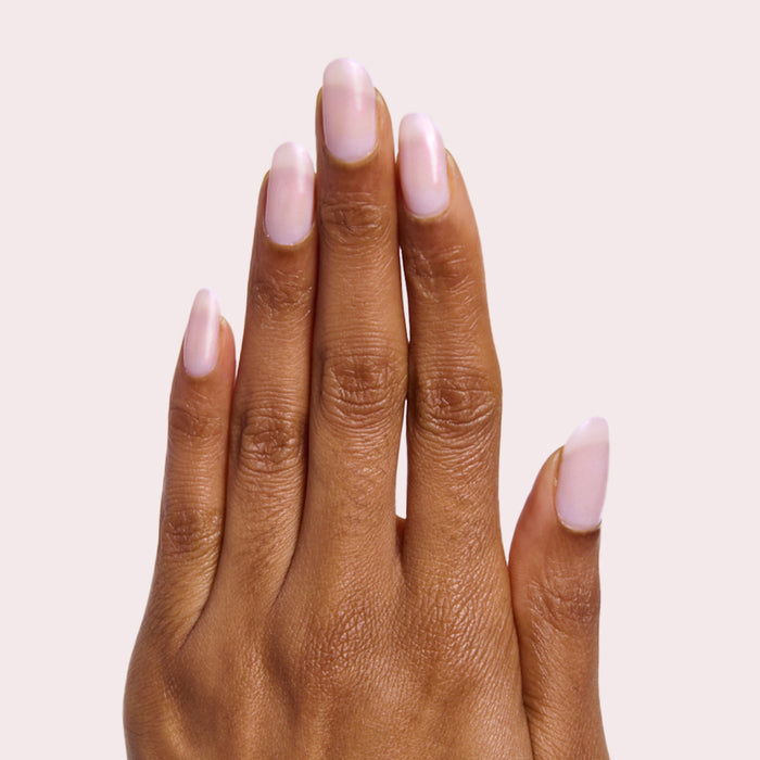 Hand with smooth nails polished in soft milky pink showing Pink Capiz for a gentle manicure look