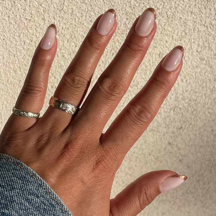 Rose Glitter French | Oval | Medium press-on manicure with shimmering rose gold glitter tips in an elegant oval shape