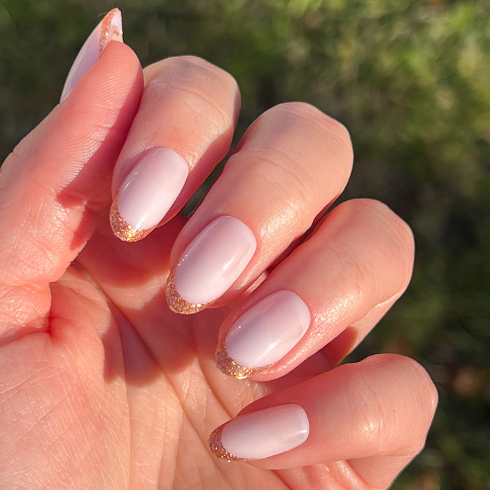 Rose Glitter French | Oval | Medium press-on manicure with soft pink base and shimmering rose gold glitter tips in an oval shape