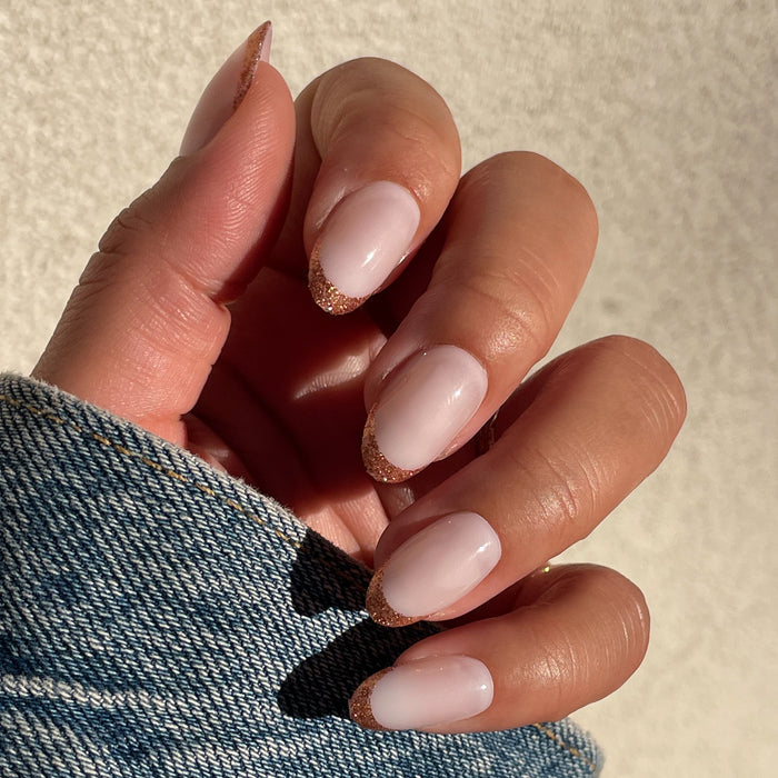 Rose Glitter French | Oval | Medium natural pink press-on manicure with sparkling rose gold tips in an elegant oval shape