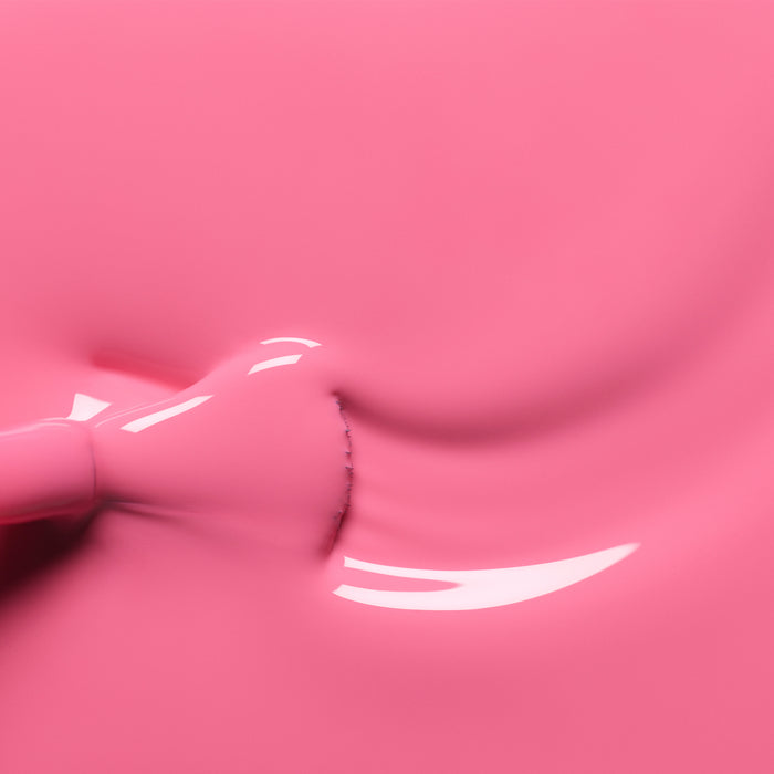 A close-up shows a brush applying Manucurist's Rose nail polish, creating smooth, flowing curves and shiny highlights on the glossy pink surface.