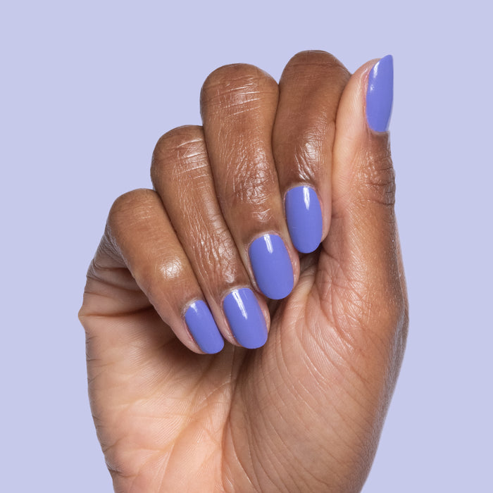 Hand with Royal quick dry polish in smooth, glossy deep purple on natural nails against light purple background