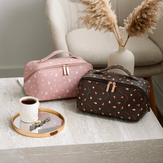 Two patterned toiletry bags on a table with a cup of coffee and decorative elements.