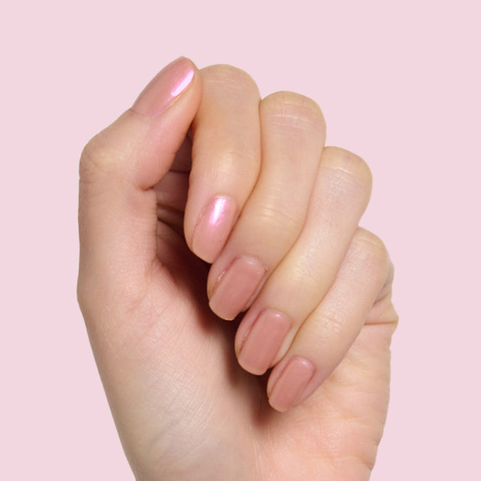 Hand with natural nails coated in Sandy Scallop showing a creamy golden iridescent long-lasting gel polish manicure