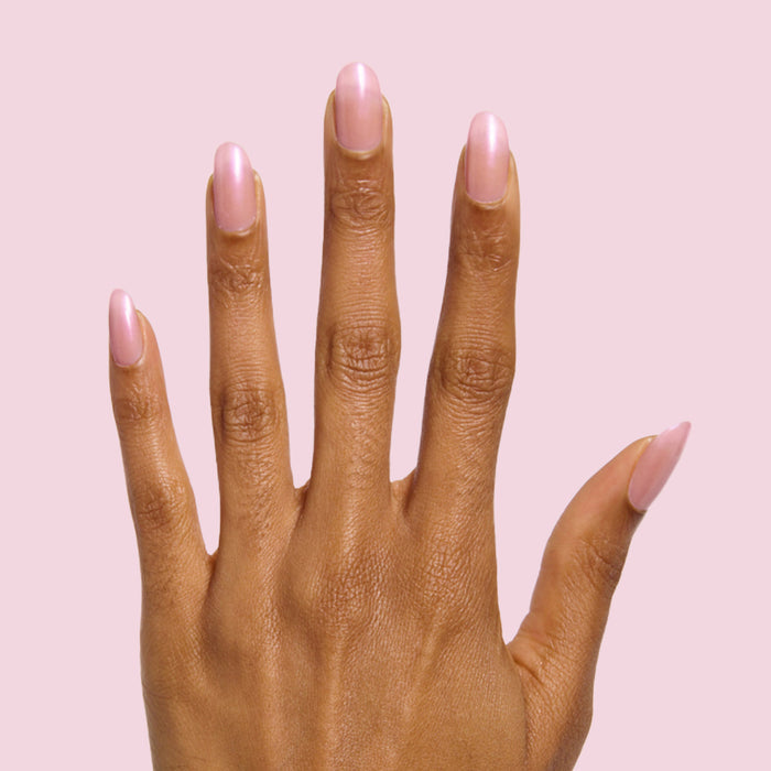 Hand with glossy nails painted in iridescent Sandy Scallop gel polish showing a soft golden manicure