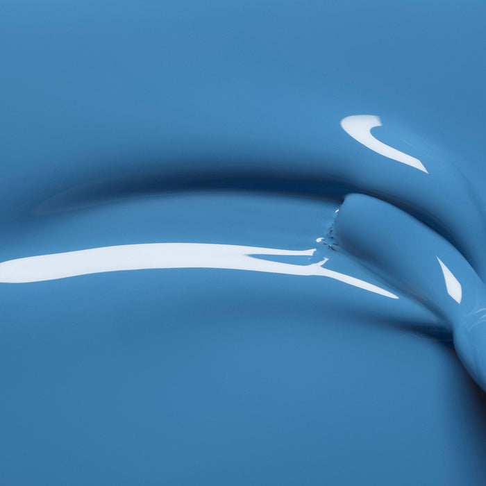 Close-up of glossy, smooth Manucurist Saphir paint with a thick, curved streak and reflective highlights, showing a jewel-toned, fluid texture.