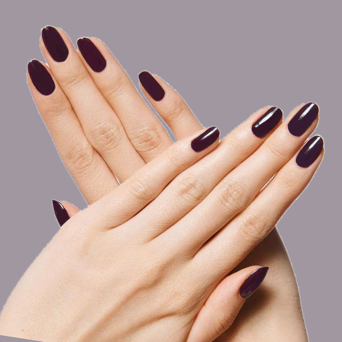 Hands with nails polished in dark plum shade SD showing a glossy, long-lasting manicure on light skin tone
