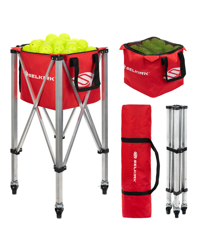 Red SELKIRK folding ball hopper on wheeled aluminum stand, with carrying bag, folded legs, and neon yellow practice balls.