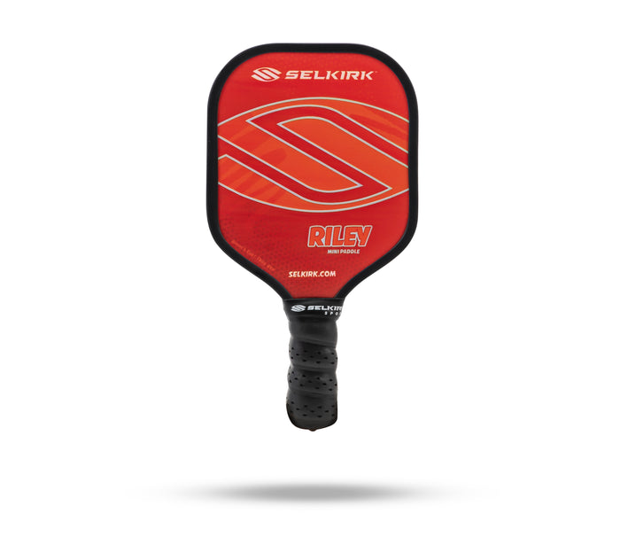 Red Selkirk Riley mini paddle with black perforated grip; face reads SELKIRK, RILEY, MINI PADDLE, SELKIRK.COM