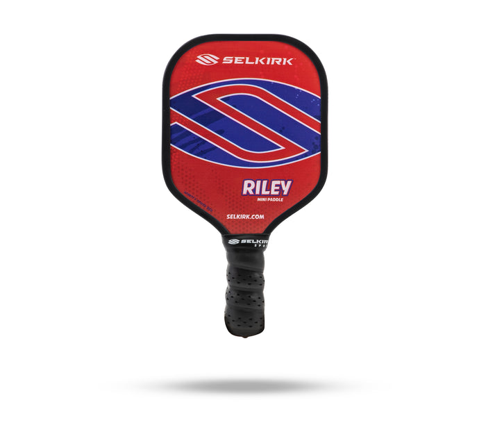 Red SELKIRK RILEY MINI PADDLE with blue S logo, SELKIRK.COM on face and SELKIRK on handle, black perforated grip