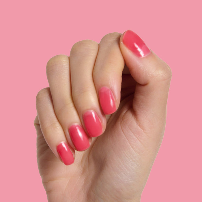 Hand with medium-length nails painted glossy jelly crimson pink in Strawberries Are in Season Right Now gel polish