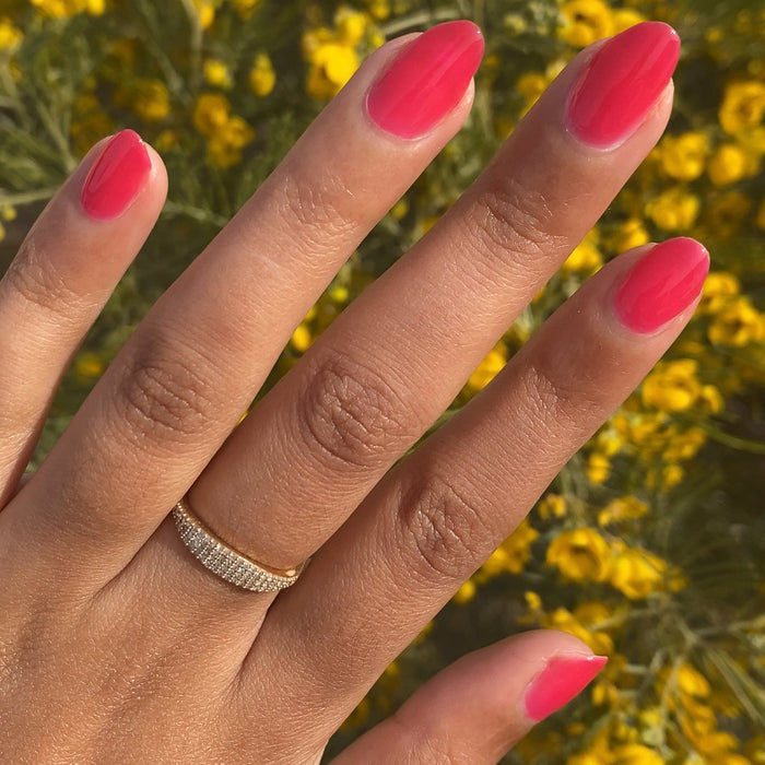 Hand with neatly shaped nails painted bright jelly red in Strawberries Are in Season Right Now gel polish outdoors