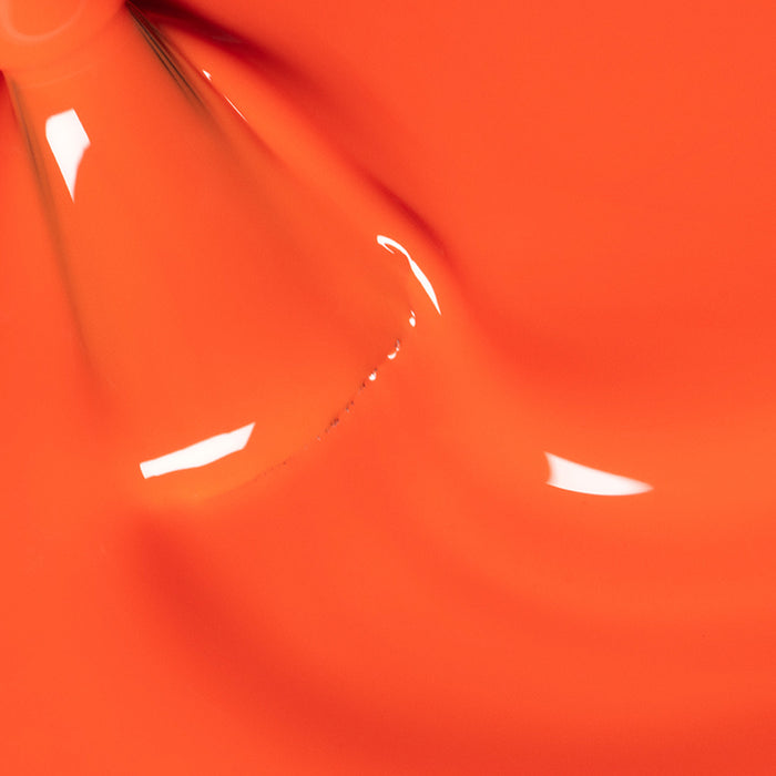 Smooth, glossy surface of vibrant orange liquid with highlights and slight ripples, suggesting a close-up of Manucurist’s Sunset nail polish.
