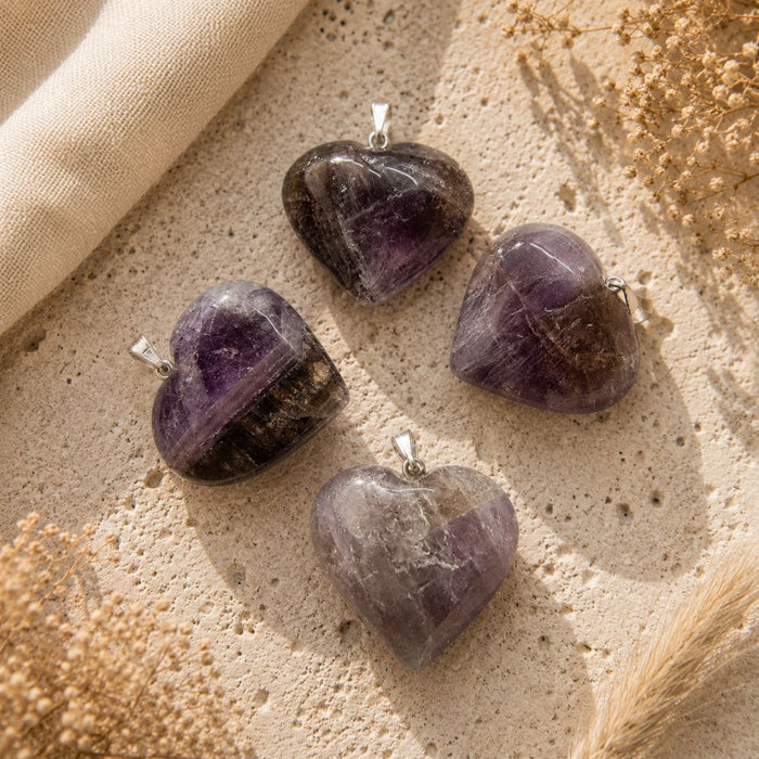 Super Seven Mini Heart Pendants on a neutral stone background
