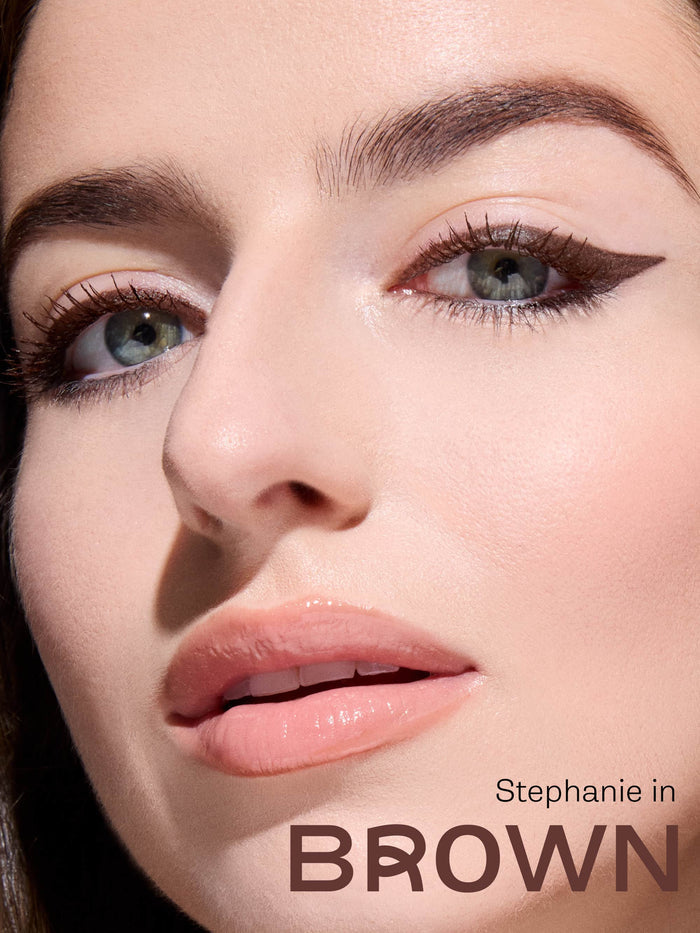 Close-up of a woman's face with eyeliner being applied, featuring the brand 'Stephanie'.