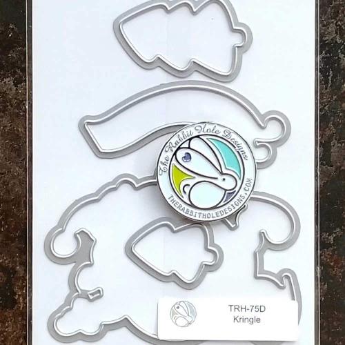 The Rabbit Hole Designs - Die Set - Kringle. The Rabbit Hole Designs dies are made of durable 100% steel Usable in nearly every machine on the market! Use on cardstock, felt, fabric or shrink plastic. You can use wafer thin dies to cut, stencil, emboss and create! Made in the USA.  Coordinates with the Kringle 4x4 Stamp Set. Available at Embellish Away located in Bowmanville Ontario Canada.