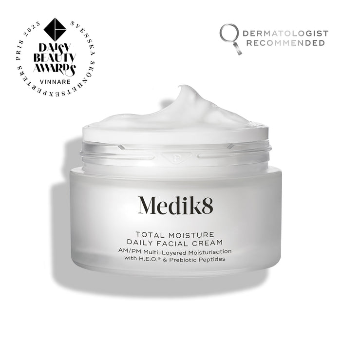 An open frosted glass jar of Medik8 Total Moisture Daily Facial Cream with a peak of white cream on top, set against a clean white background. Badges in the top corners indicate it is a "Daisy Beauty Awards Vinnare 2025" (Winner) and "Dermatologist Recommended."