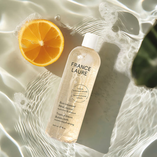 France Laure Tropical Dream Bubble Bath with natural botanical extracts, shown in water with orange slice, moisturizing & relaxing