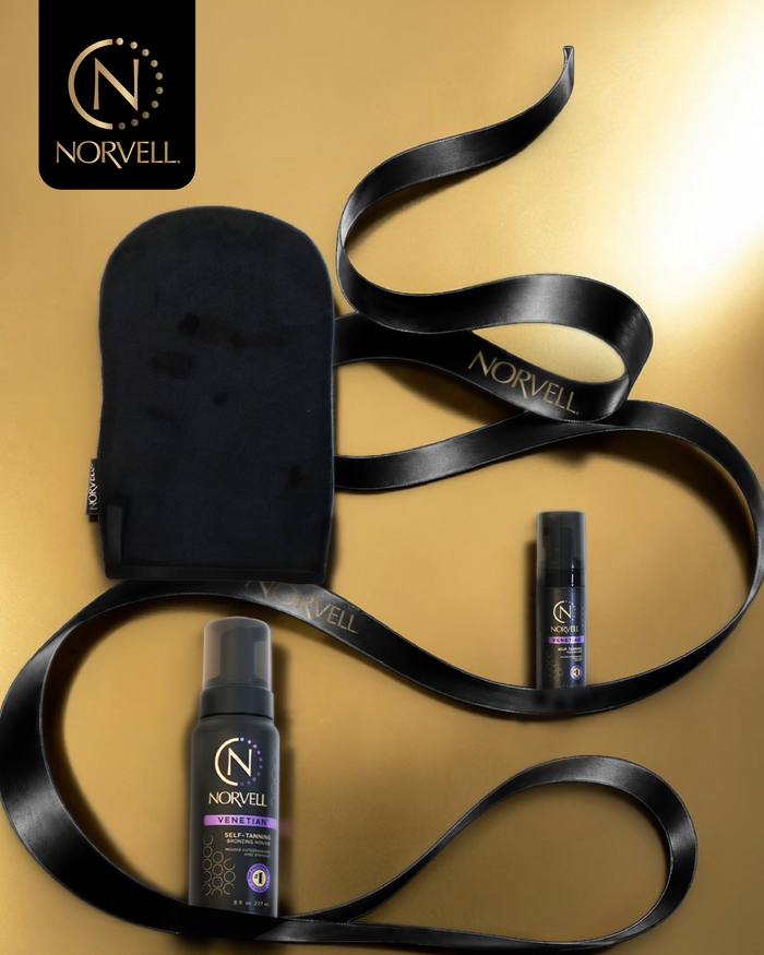 Norvell sunless tanning products including a black mitt, spray bottles, and a ribbon on a gold background.